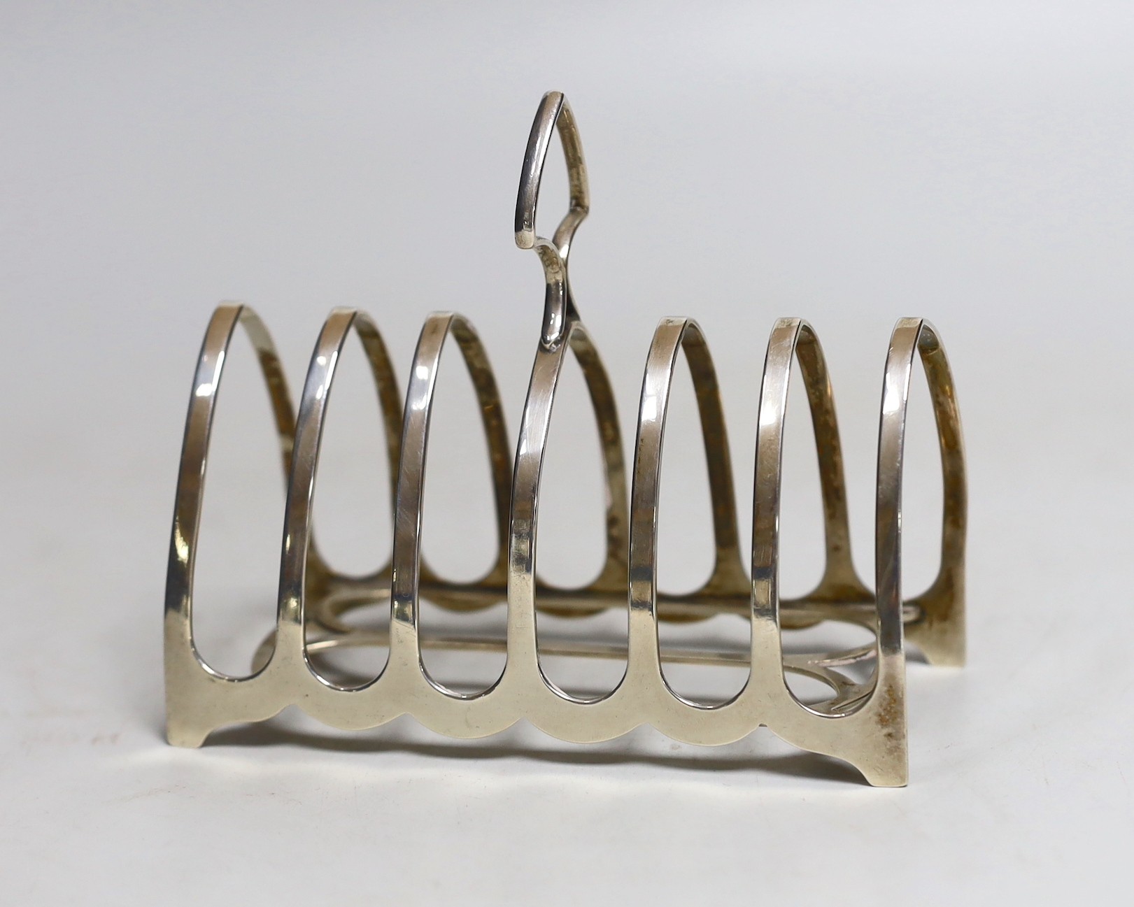 A George V silver seven bar toast rack by William Hutton & Sons, 12.2cm and two silver small pin dishes.